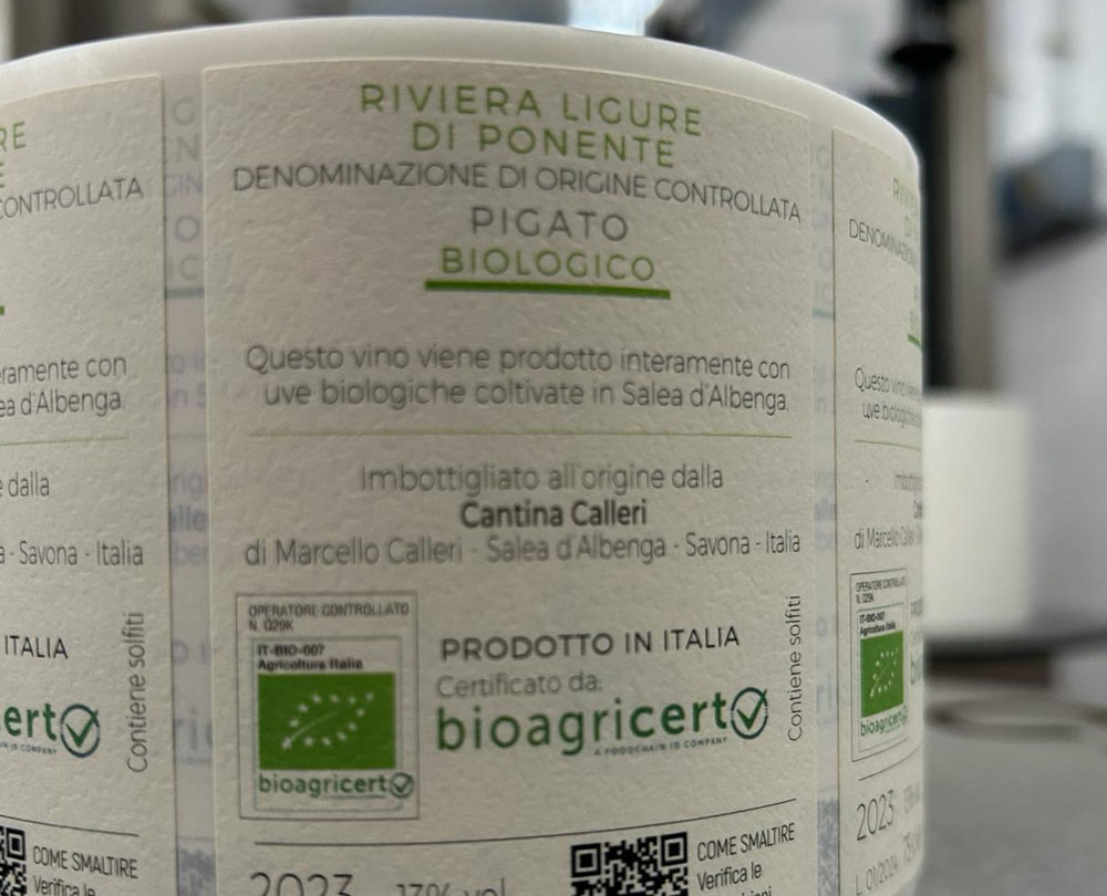 Rotolo di etichette adesive in primo piano da apporre sulle bottiglie di Pigato DOC per attestare la certificazione biologica